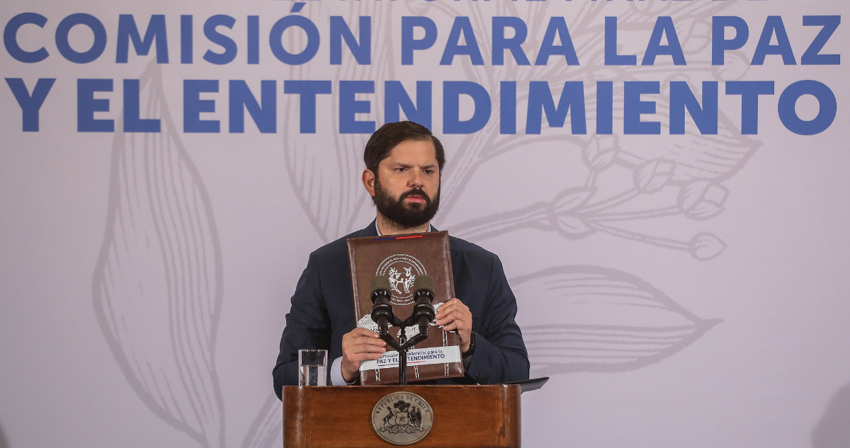 Gabriel Boric sosteniendo texto con propuestas de Comisión Para La Paz valorado por Consejo del INDH