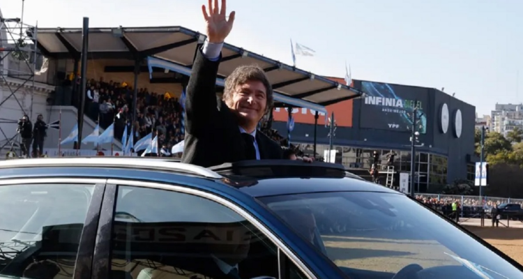 Presidente Javier Milei saluda desde su automóvil en Argentina.