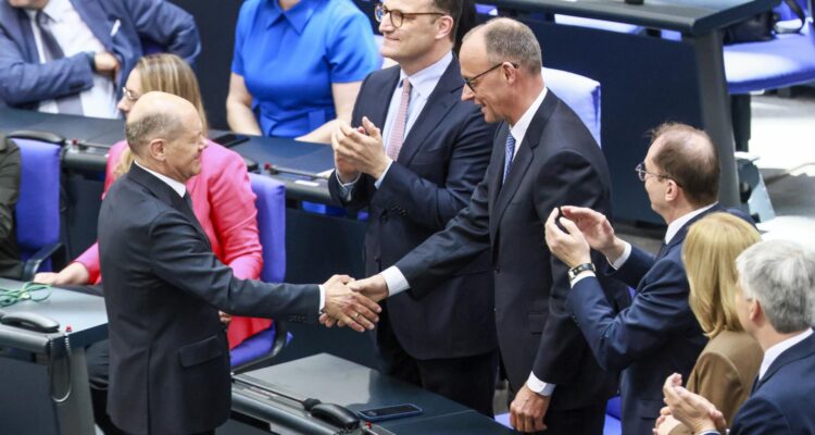 El canciller alemán saliente, Olaf Scholz (i), felicita al recién elegido canciller Friedrich Merz