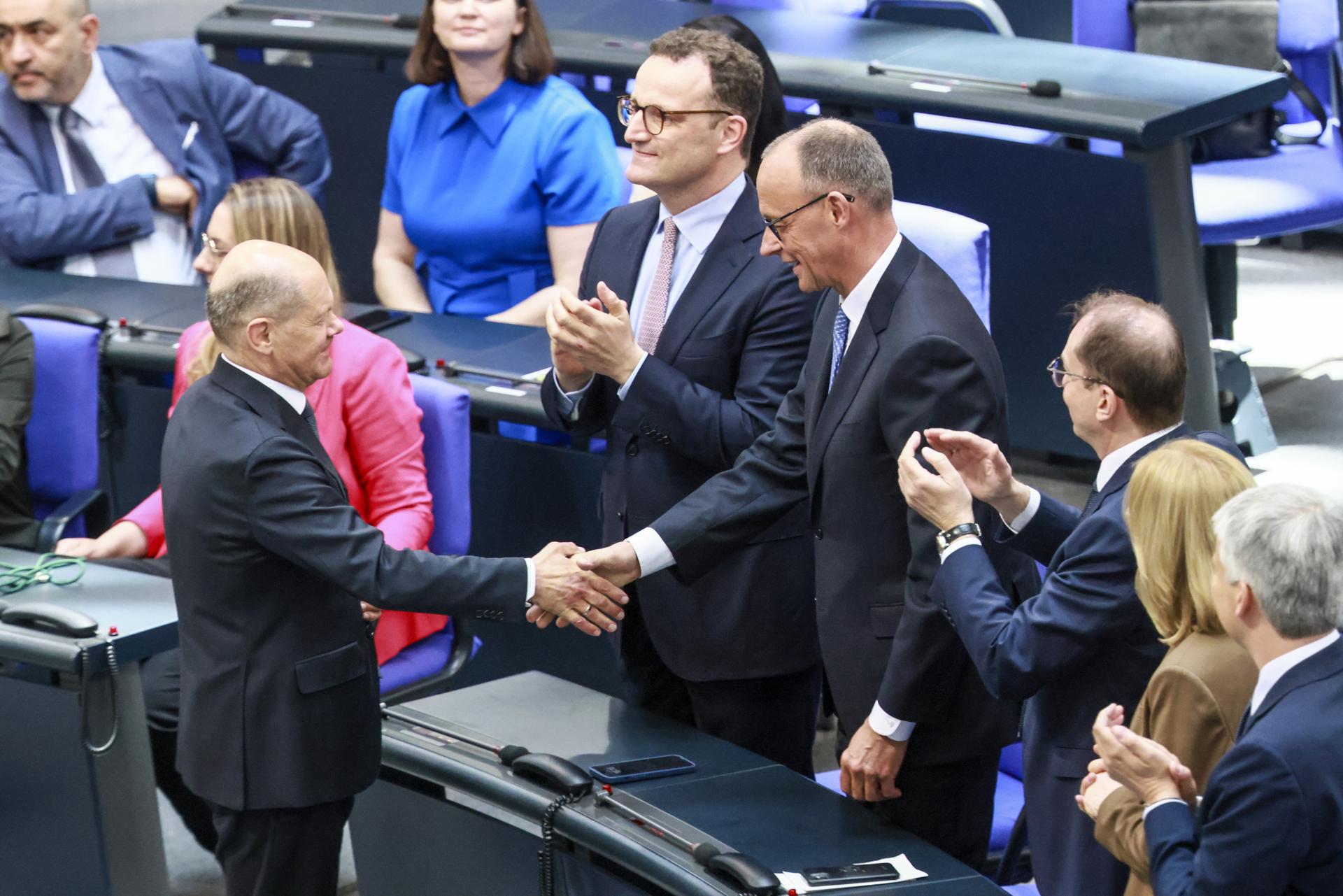 El canciller alemán saliente, Olaf Scholz (i), felicita al recién elegido canciller Friedrich Merz