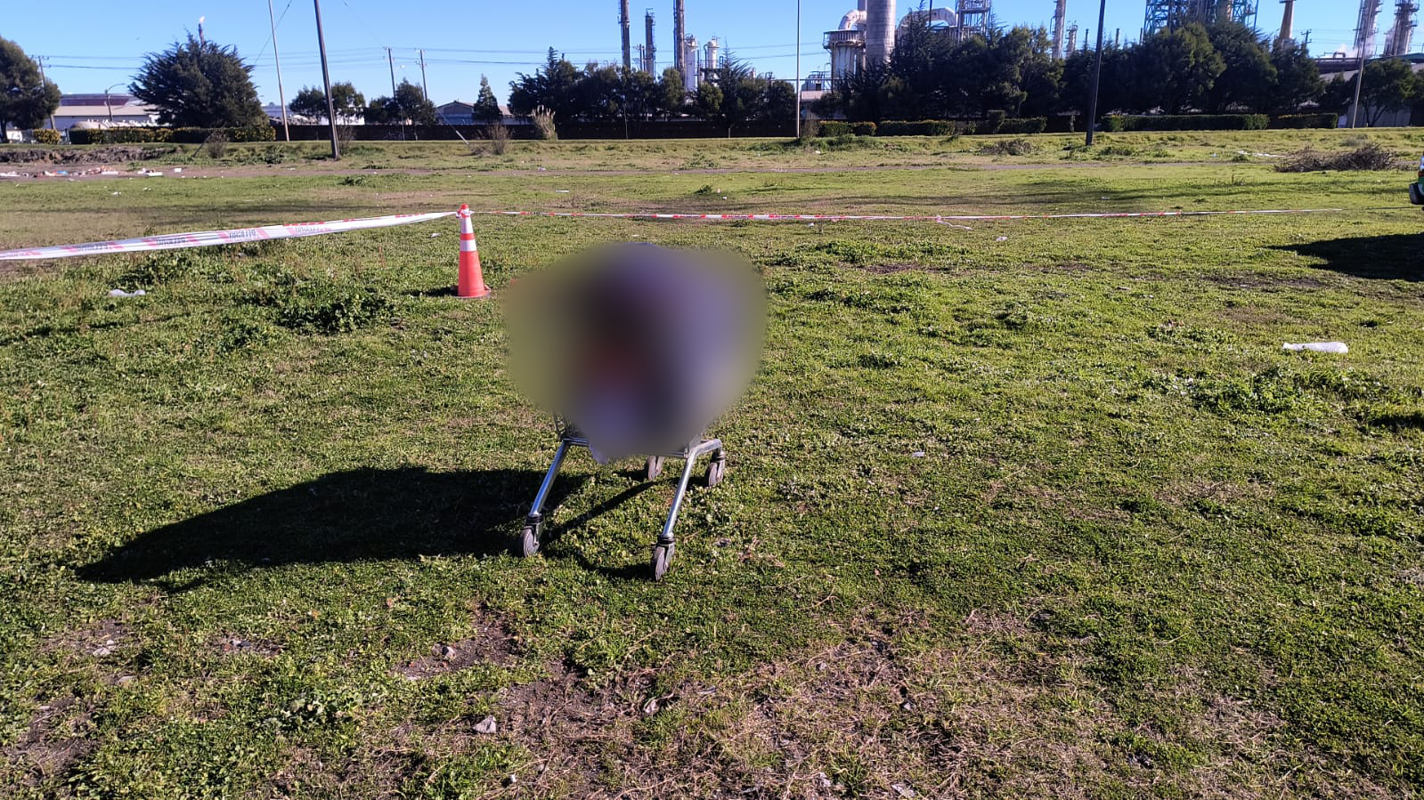 Carro de supermercado con cadáver (se encuentra difuminado).