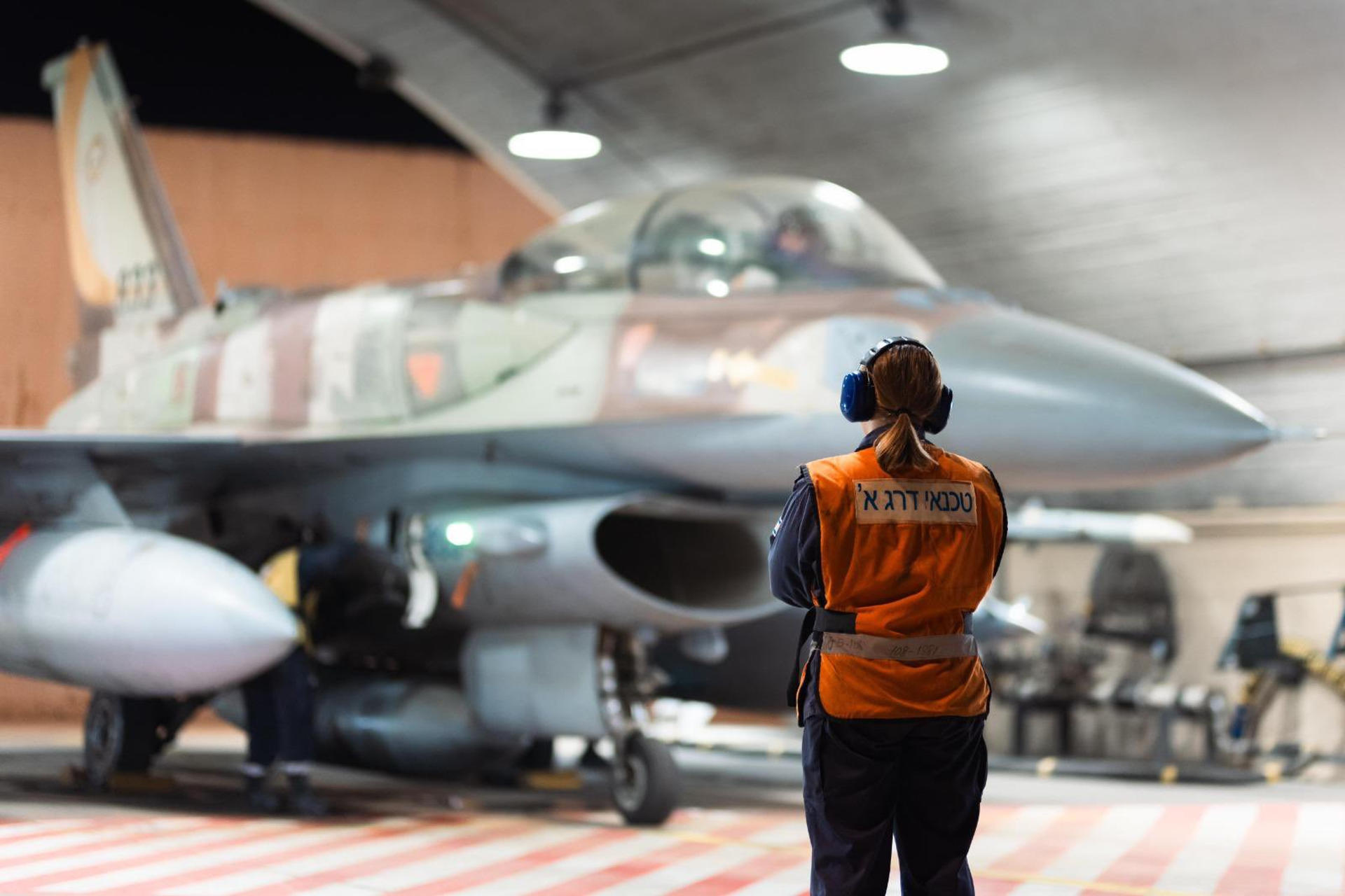 Imagen compartida por las Fuerzas de Defensa de Israel de una funcionaria junto a un avión antes de los ataques contra Irán