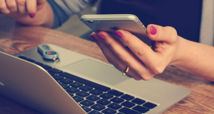 Persona con su computador y celular para columna sobre infoxicación y brain-rot