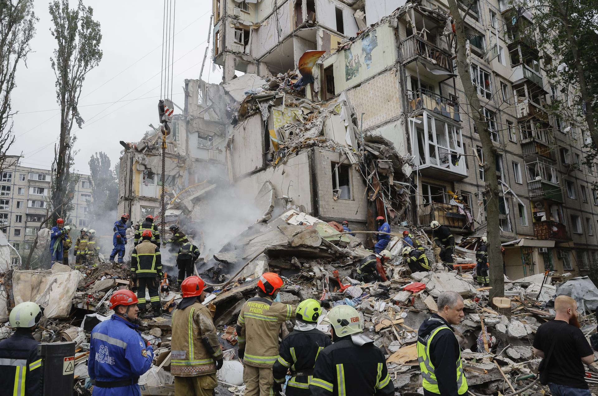 Rescatistas trabajan en el lugar de un ataque ruso contra un edificio residencial de nueve pisos en Kiev