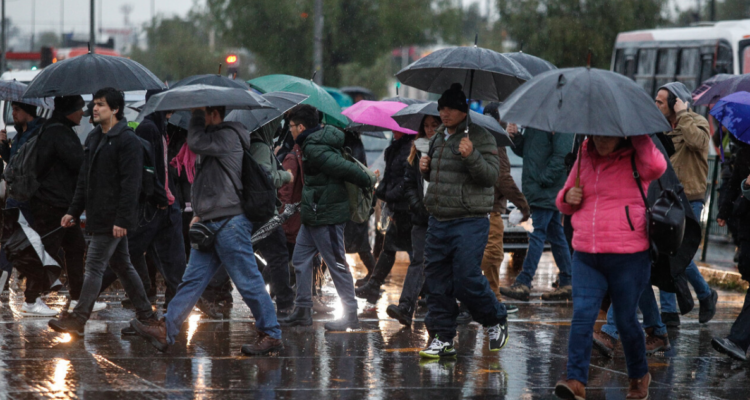 Grupo de personas bajo la lluvia en referencia a alerta temprana en la región de La Araucanía