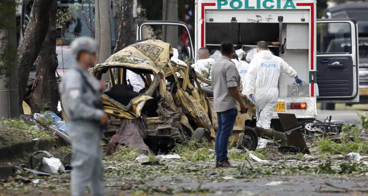 Miembros de la Dirección de Investigación Criminal e Interpol (DIJIN) inspeccionan un vehículo tras la explosión en Cali
