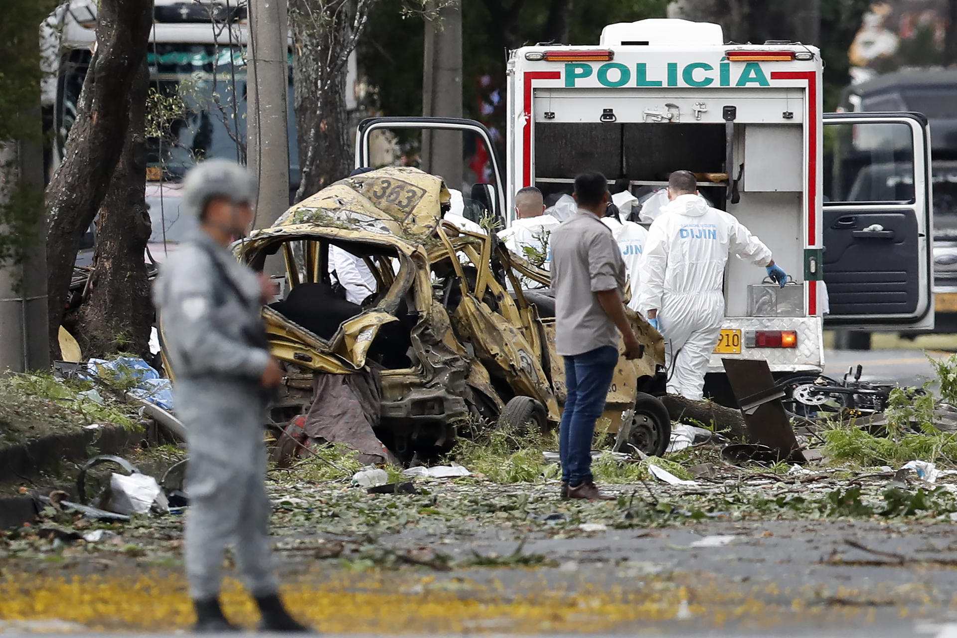 Miembros de la Dirección de Investigación Criminal e Interpol (DIJIN) inspeccionan un vehículo tras la explosión en Cali