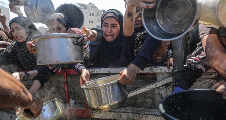 Palestinos desplazados, incluidos niños, reciben comida de una cocina benéfica en la ciudad de Gaza