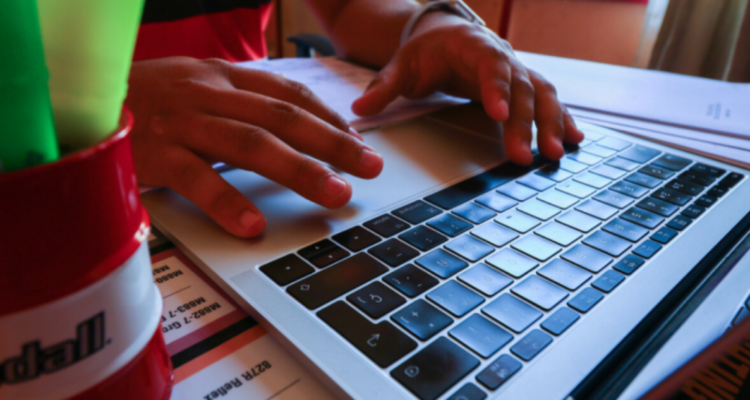 Fotografía muestra manos de un niño en el teclado de un computador