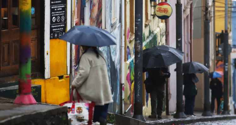 Personas con paraguas en la calle por sistema frontal en la región de Valparaíso
