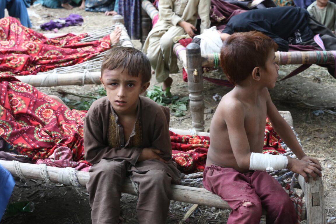 Los niños afectados por el terremoto descansan fuera de sus casas dañadas en Kunar, Afganistán