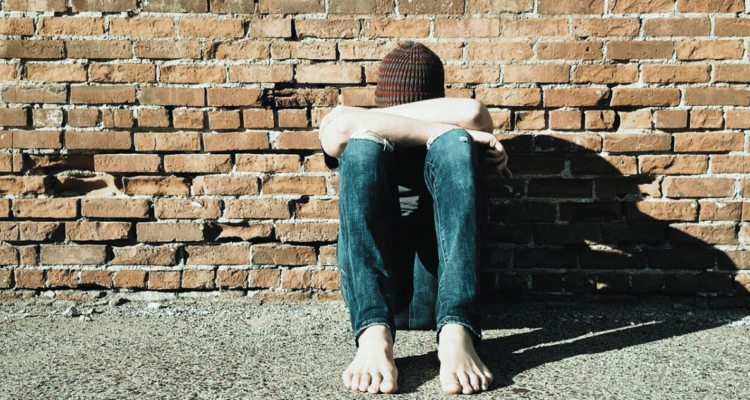 Joven vulnerable sentado en la calle