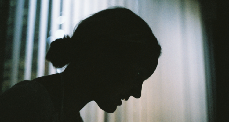Foto de mujer en sombras para columna sobre femicidio suicida