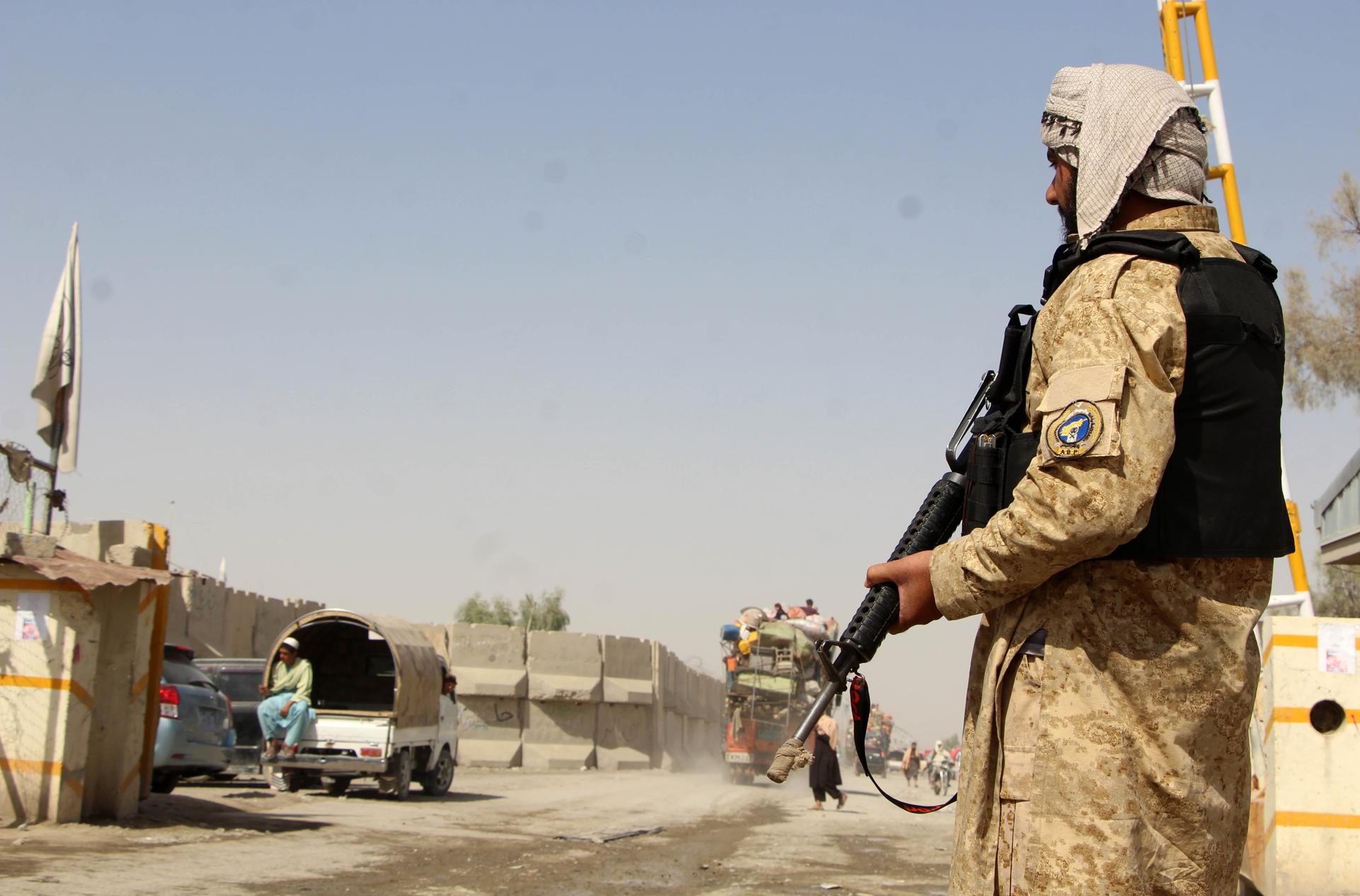 Un afgano hace guardia en la frontera mientras los refugiados regresan tras la reapertura del cruce en Kandahar, Afganistán