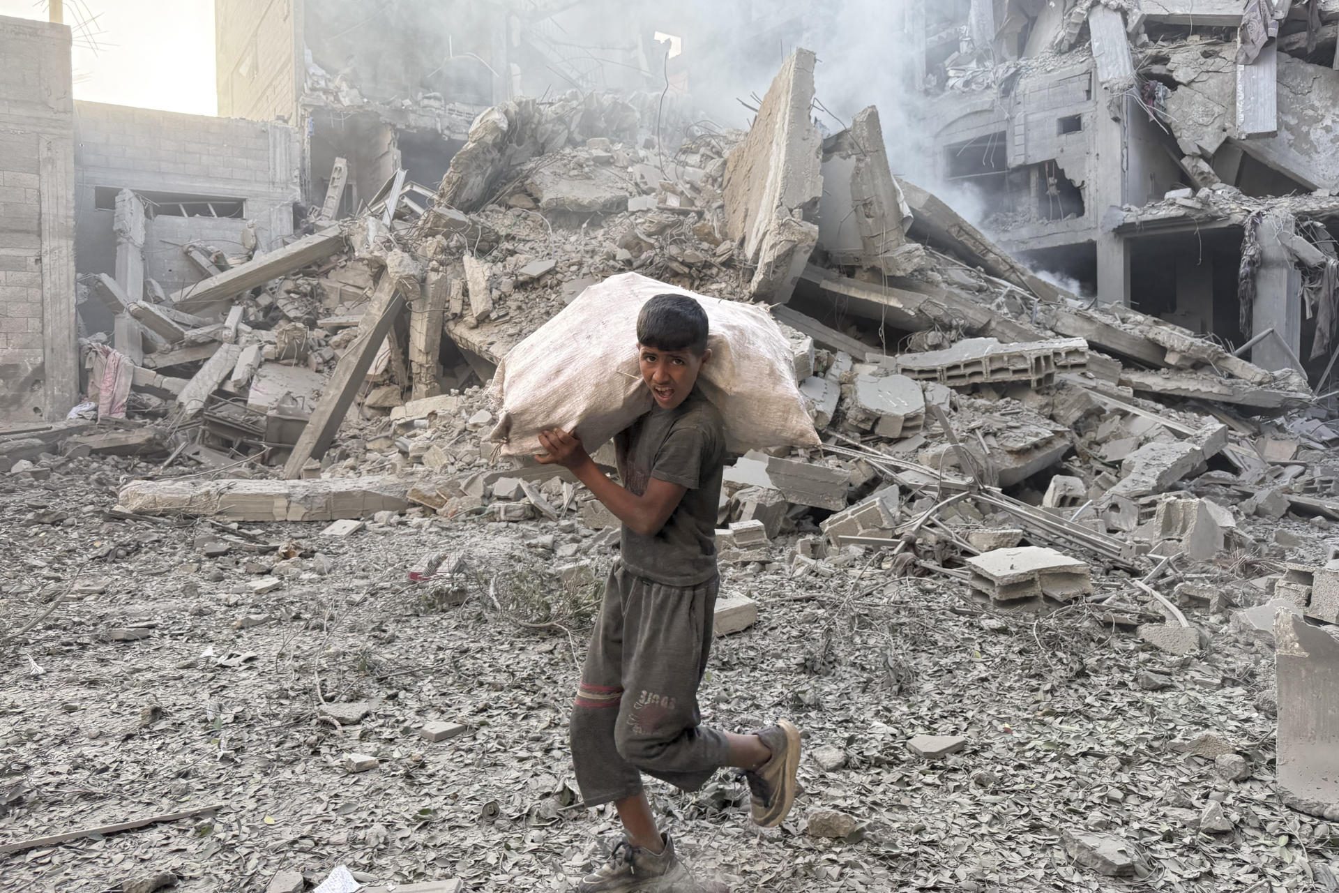 Un joven camina por los escombros tras un ataque israelí en el campamento de refugiados de Bureij, en Gaza