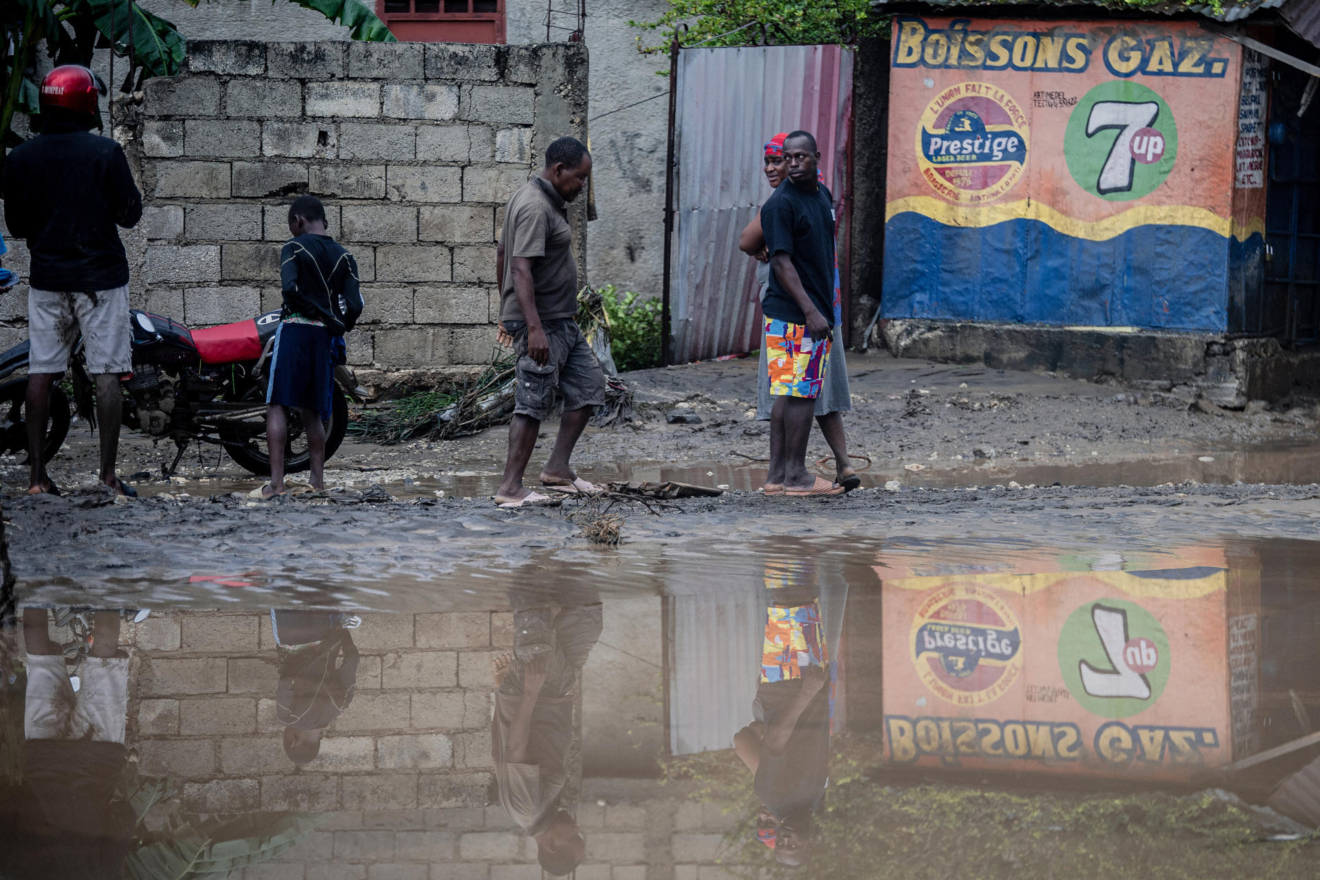 Personas caminan por una calle inundada por el paso del huracán Melissa en Petit-Goâve, Haití