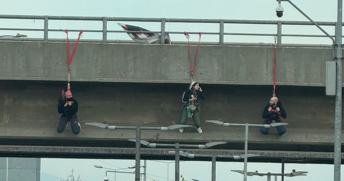 Personas se cuelgan del paso sobre nivel de la rotonda Grecia durante nueva protesta en la capital