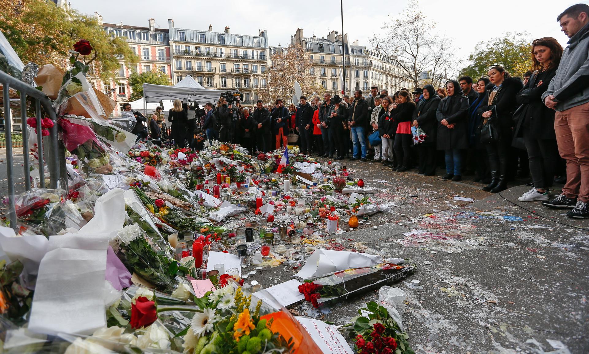 Personas realizan un minuto de silencio cerca de la sala Bataclan tres días después de los atentados 