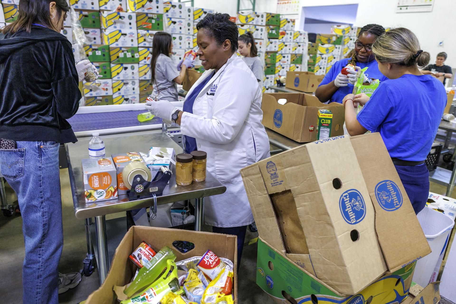 Voluntarios almacenan artículos en un banco de alimentos en Pembroke Park, Florida