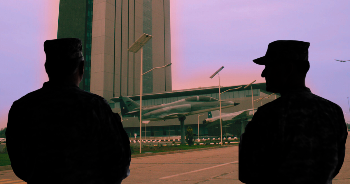 Dos funcionarios FACH de espalda a un edificio de la base de la institución en cerrillos.