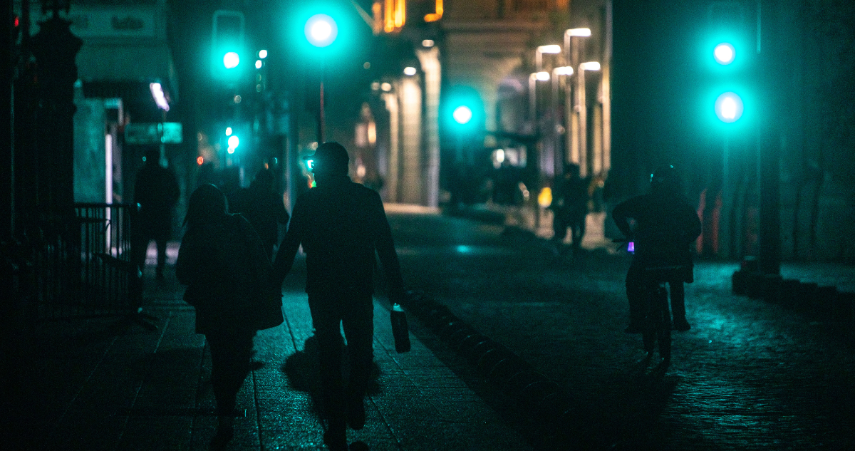 Foto de contexto de personas caminando en calle oscura