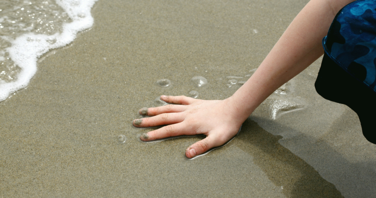 Foto de una mano en la arena para ilustrar nota sobre el séptimo sentido de los humanos