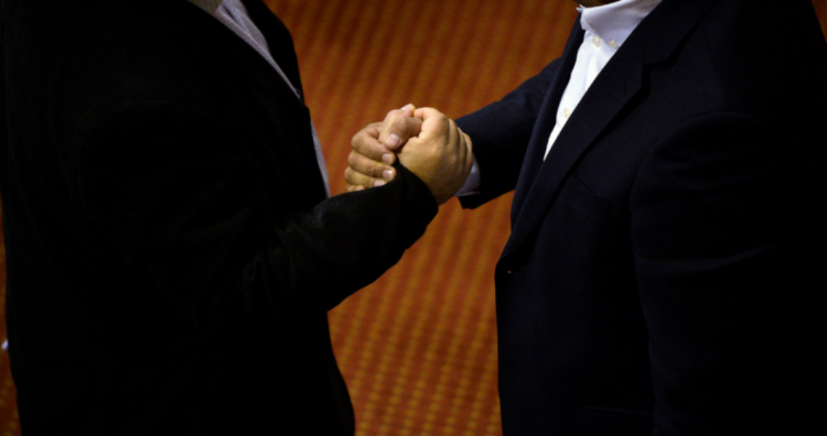 Foto de contexto de dos hombres dándose la mano