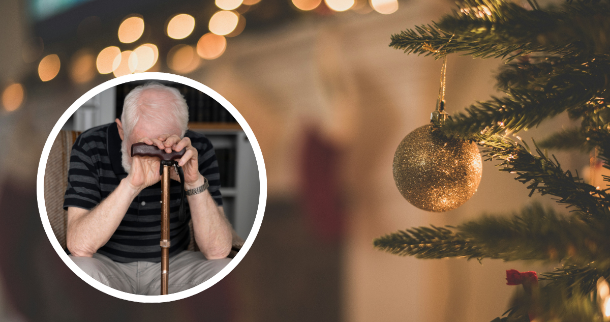 Anciano triste con el rostro apoyado en su bastón. Y foto de fondo de árbol de Navidad