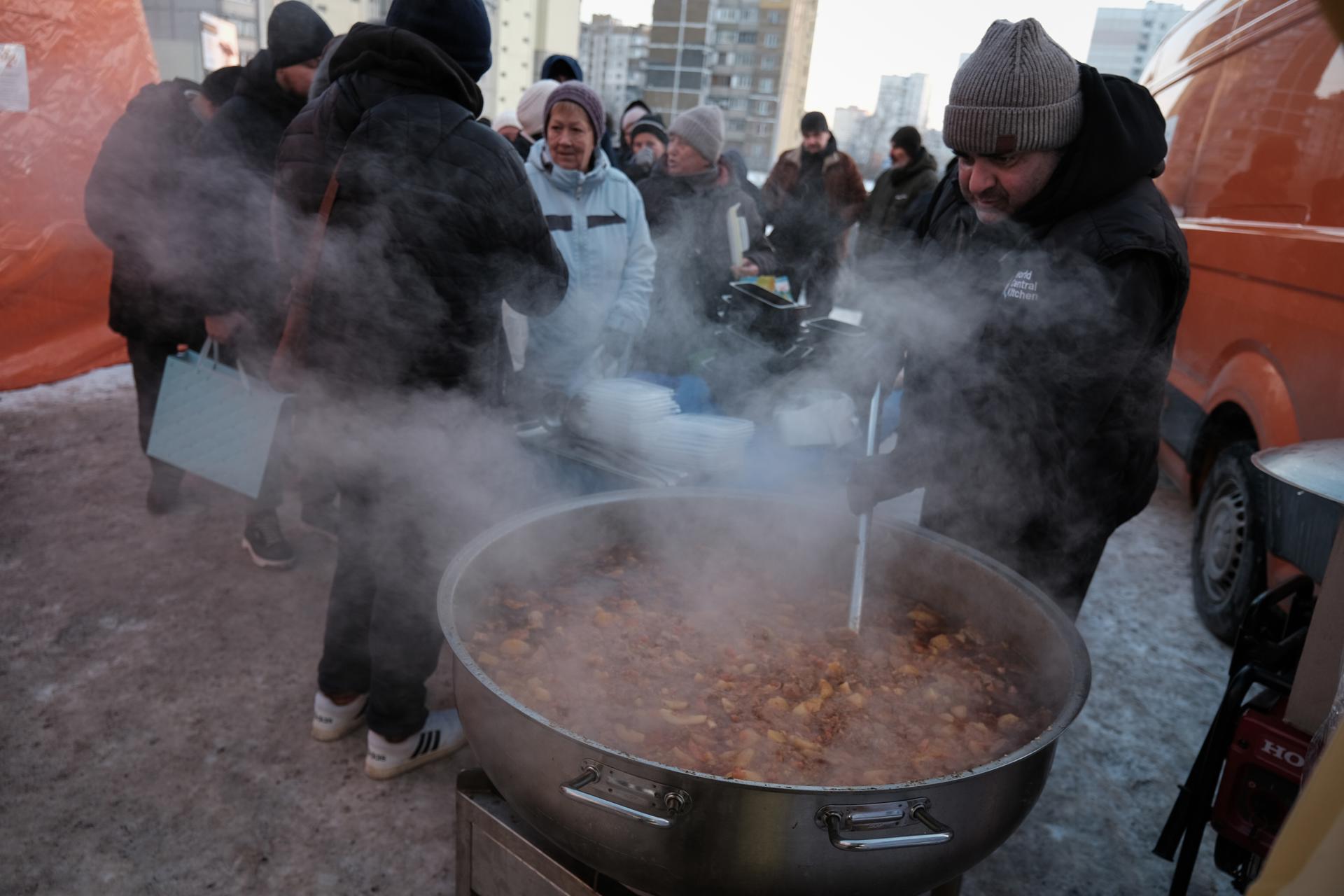 Un trabajador de la ONG World Central Kitchen distribuye comida caliente en una zona residencial de Kiev