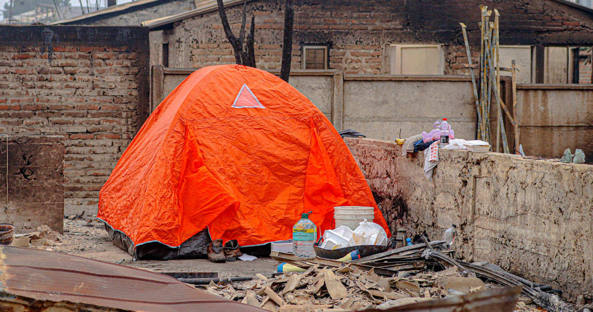 Víctimas de incendios en Lirquén. Fotografía muestra una carpa naranja instalada en el terreno de una vivienda que resultó quemada