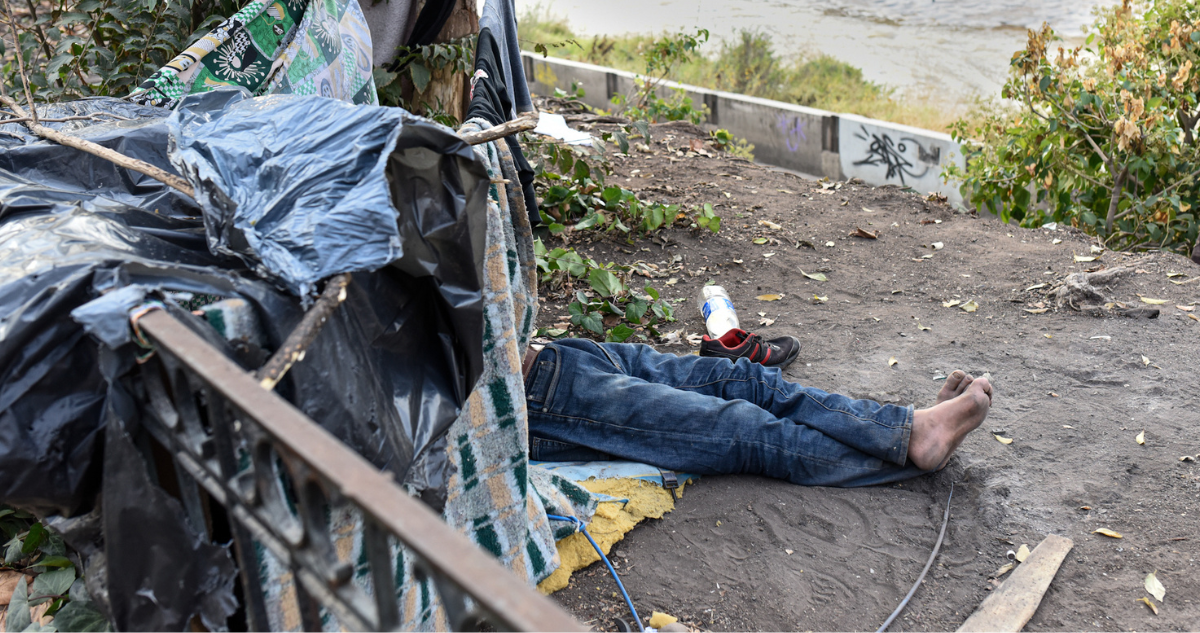 Persona en una tienda hecha con mantas y trozos de madera