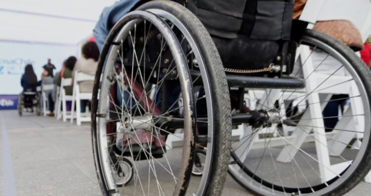 Persona en silla de ruedas ingresando a salón.