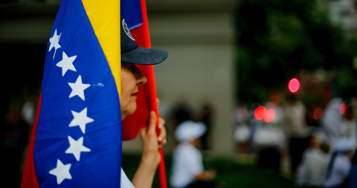 Mujer con bandera de Venezuela en celebración tras detención de Maduro.