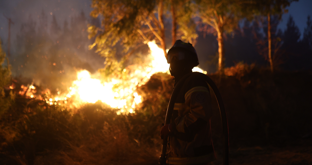 Foto de un bombero combatiendo un incendio en Concepción, Chile
