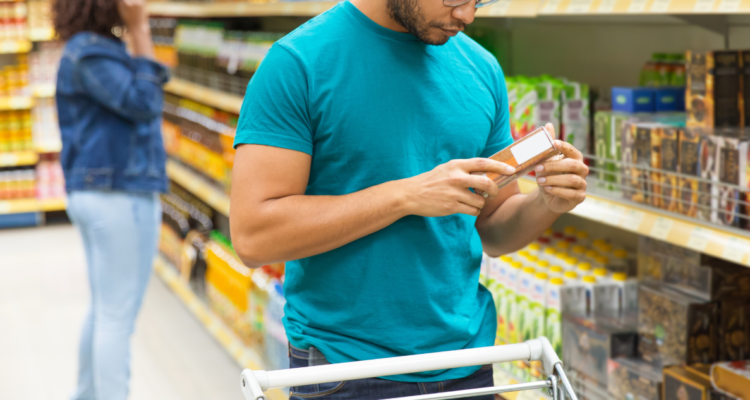 Persona leyendo la etiqueta de un alimento en el supermercado