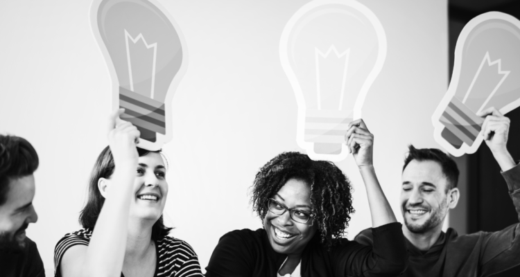 Foto de contexto para desarrollo humano, muestra personas compartiendo ideas reflejadas en una ampolleta sobre sus cabezas.