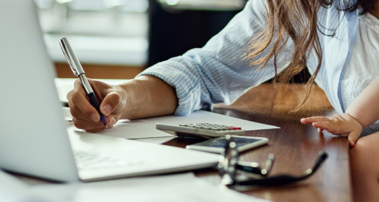 Madre joven trabajando con bebé en sus brazos