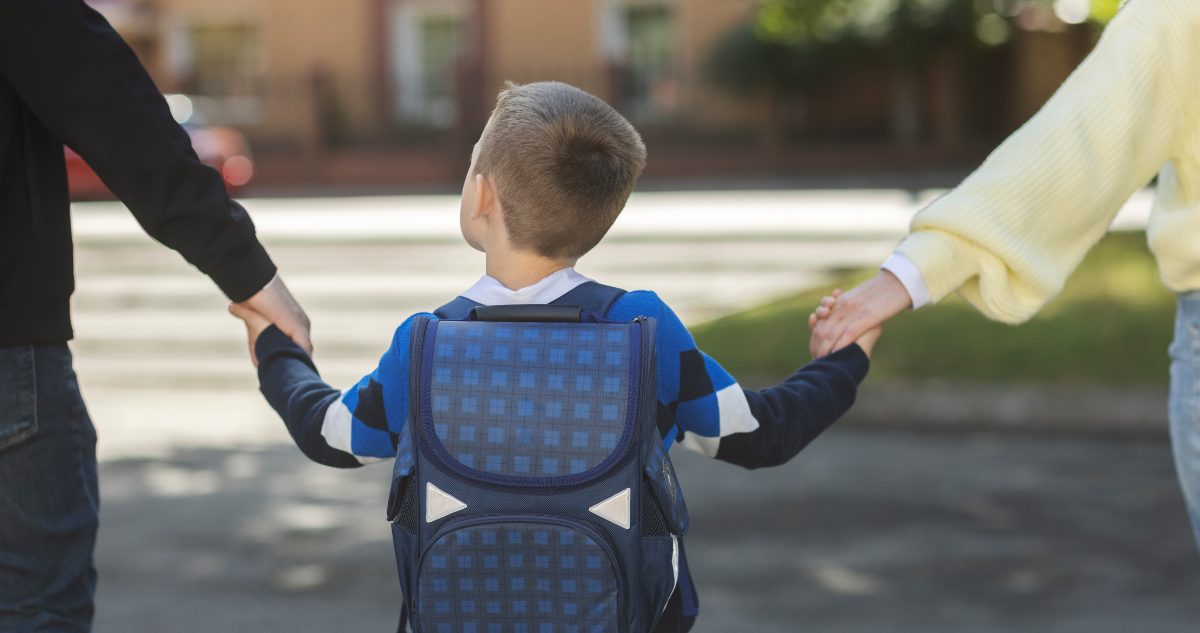 Papás llevando a su hijo al colegio.