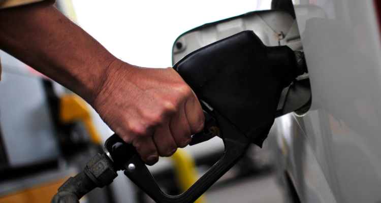 Detalle de una mano sosteniendo un surtidor de combustible