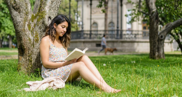 Joven leyendo sobre el paso en el Parque Forestal de Santiago