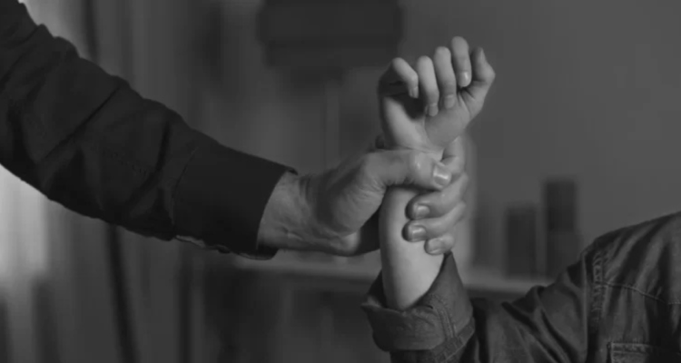 Foto de contexto de hombre sujetando del brazo a una mujer