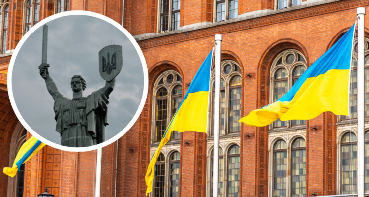 Banderas de Ucrania y estatua con escudo de Ucrania.