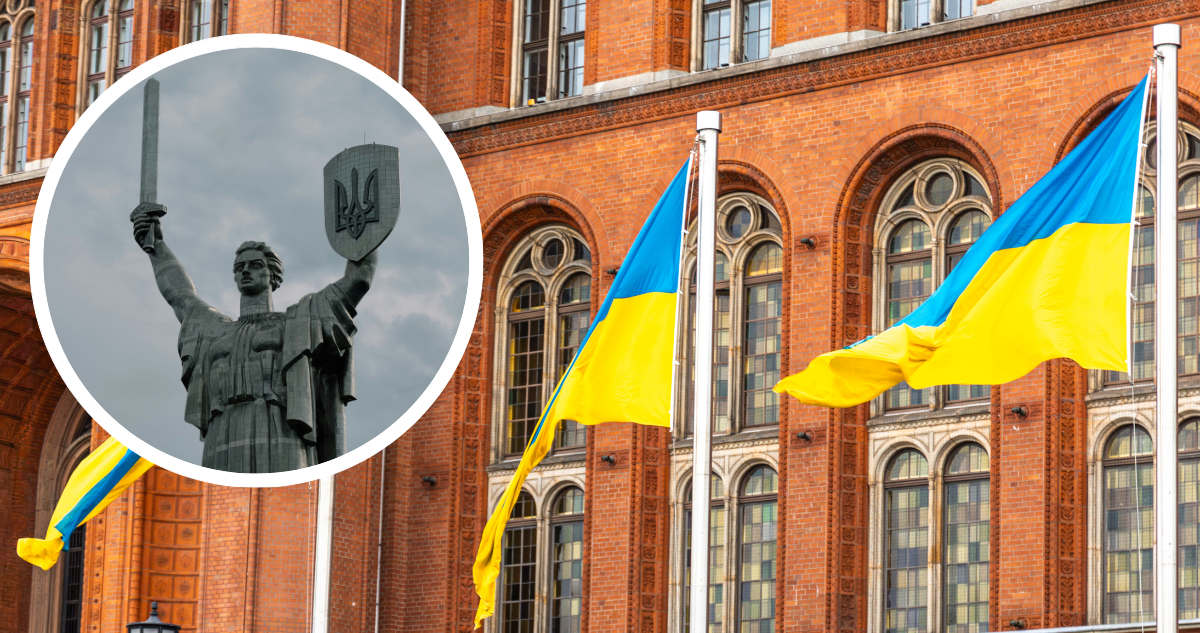 Banderas de Ucrania y estatua con escudo de Ucrania.