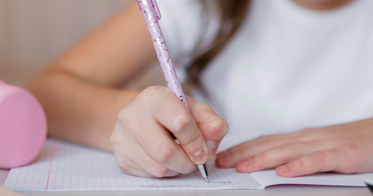 Niña escribiendo en un cuaderno
