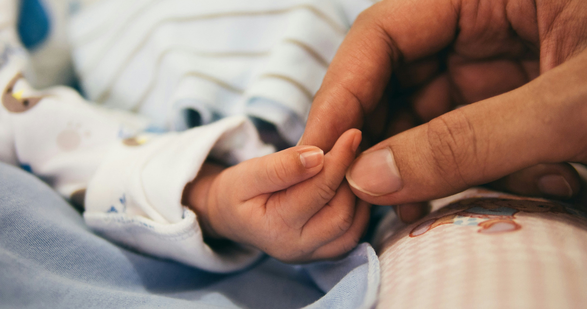 Manos de mamá y su hijo recién nacido.