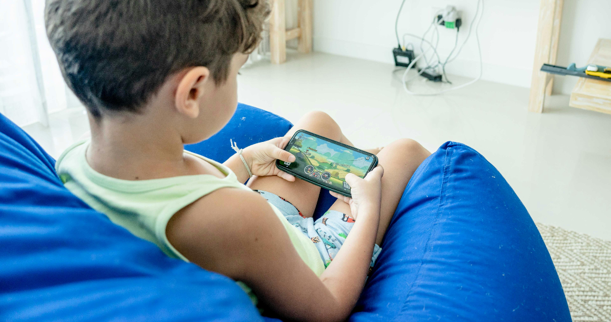 Foto de un niño jugando videojuegos para ilustrar nota sobre el grooming