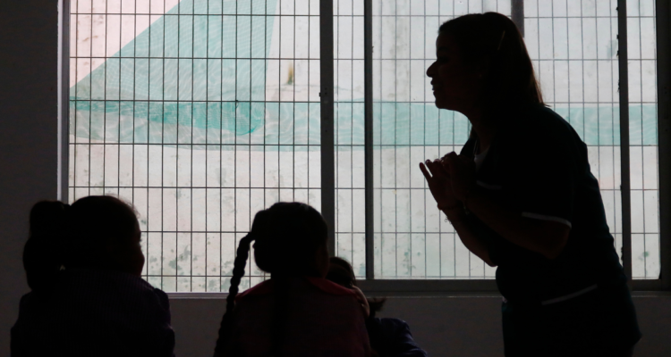 Profesora y alumnos en sombras