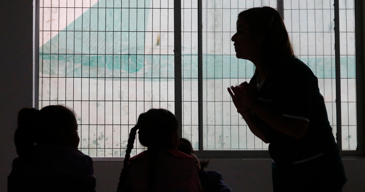Profesora y alumnos en sombras