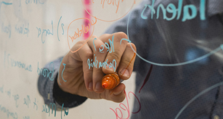 Persona escribiendo ideas en una pizarra