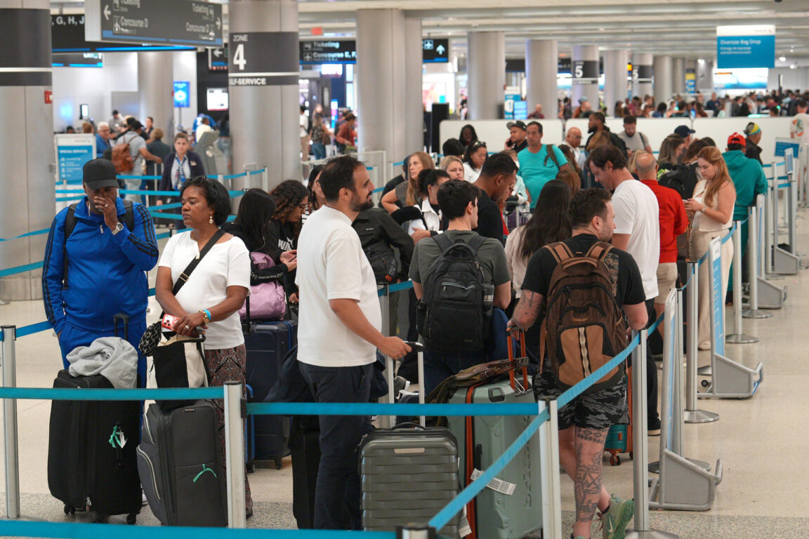 Personas esperan en la fila para abordar un avión con destino a Caracas este jueves